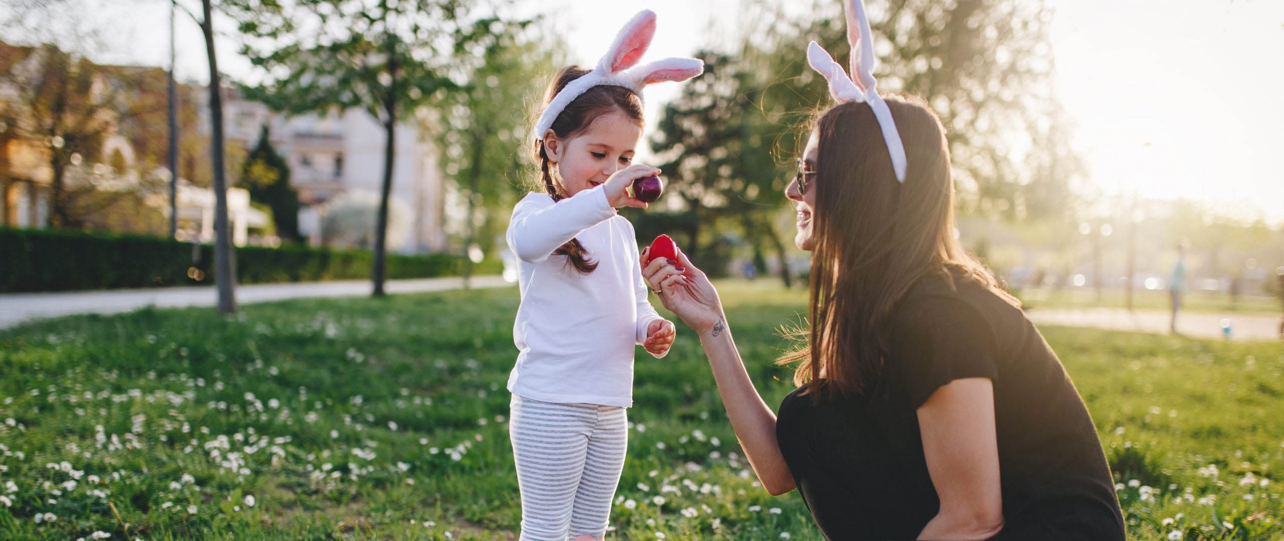 Cute little four year old girl enjoying Easter egg hunt in a public park